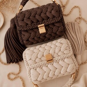 May include: Two rectangular handbags crafted from thick braided cord, one in dark brown and one in cream. Each bag features a gold-tone rectangular clasp, a matching braided top handle with gold hardware, and a long gold chain strap with a large tassel.
