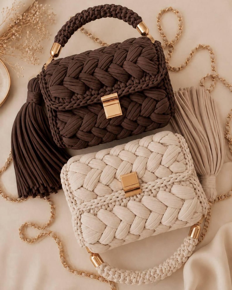May include: Two rectangular handbags crafted from thick braided cord, one in dark brown and one in cream. Each bag features a gold-tone rectangular clasp, a matching braided top handle with gold hardware, and a long gold chain strap with a large tassel.