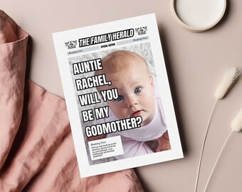 May include: A newspaper-style card with a photo of a baby looking up at the camera. The headline reads "Auntie Rachel, Will You Be My Godmother?"