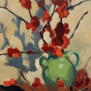 Peut inclure: Un pichet en céramique vert rempli de fleurs rouges. Les fleurs sont disposées dans un style lâche et naturel. Le pichet est posé sur une table avec une surface brune.