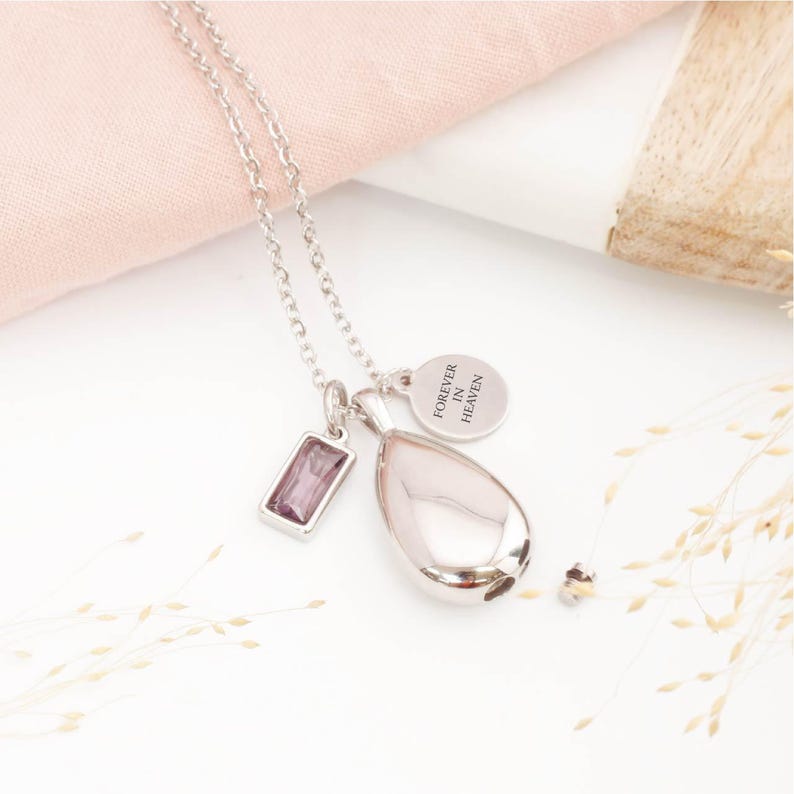Silver teardrop urn necklace with February birthstone and personalised engraved tag for ashes