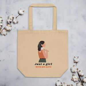 Könnte beinhalten: Beigefarbene Einkaufstasche mit einer Grafik einer Frau, die Blumen hält, und dem Text "Just a girl with big data".