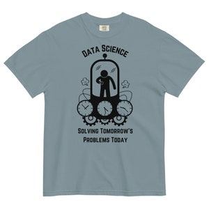 May include: A light blue t-shirt with a black graphic of a person in a time machine with the text "Data Science Solving Tomorrow's Problems Today".