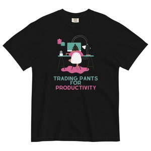 Può includere: T-shirt nero con la scritta "TRADING PANTS FOR PRODUCTIVITY" in turchese e rosa. La grafica raffigura una persona che lavora a una scrivania con un computer. La maglietta è di vestibilità ampia.