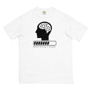 Könnte beinhalten: Weißes T-Shirt mit einer schwarzen Grafik eines menschlichen Kopfes mit einem Schaltkreis-Gehirn im Inneren. Die Grafik enthält auch eine Fortschrittsanzeige mit der Aufschrift "Machine learning in progress."