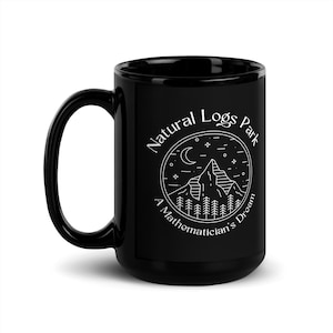 May include: Black ceramic mug with a white graphic design of a mountain range, moon, and stars inside a circle with the text "Natural Logs Park A Mathematician's Dream".