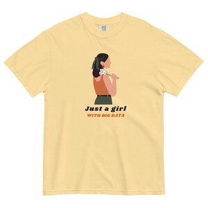 Könnte beinhalten: Ein gelbes T-Shirt mit einem Motiv einer Frau, die Blumen hält. Der Text "Just a girl with big data" ist auf dem Shirt aufgedruckt.