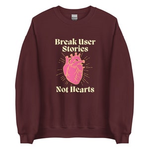 Peut inclure: Sweat-shirt bordeaux avec un graphique de cœur et le texte "Break User Stories Not Hearts" en jaune.