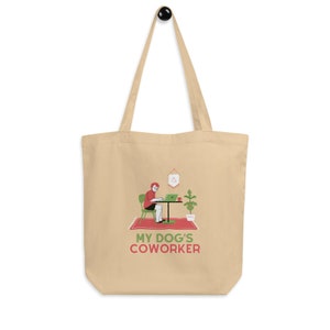 May include: A beige tote bag with a red and green illustration of a person working on a laptop at a desk. The text "MY DOG'S COWORKER" is printed in red and green on the bag.