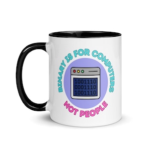 May include: White ceramic mug with a black rim and handle. The mug features a purple circle with the text "BINARY IS FOR COMPUTERS NOT PEOPLE" in a blue and pink font. Inside the circle is a cartoon computer screen with the binary code "10011110 00011110 10011110" displayed.