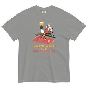 以下が含まれることがあります： グレーのTシャツに、椅子に座ってラップトップとコーヒーカップを持った人のグラフィックがプリントされています。Tシャツには「Trading Pants for Productivity」という文字がプリントされています。