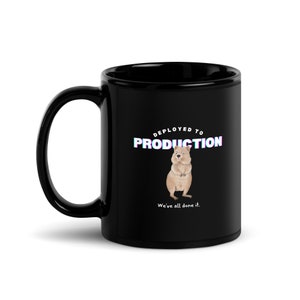May include: Black ceramic coffee mug with a white graphic of a quokka and the text "Deployed to Production. We've all done it."