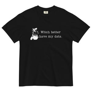 以下が含まれることがあります： 黒いTシャツに、白い魔女と釜のグラフィックと「Witch better have my data.」というテキストがプリントされています