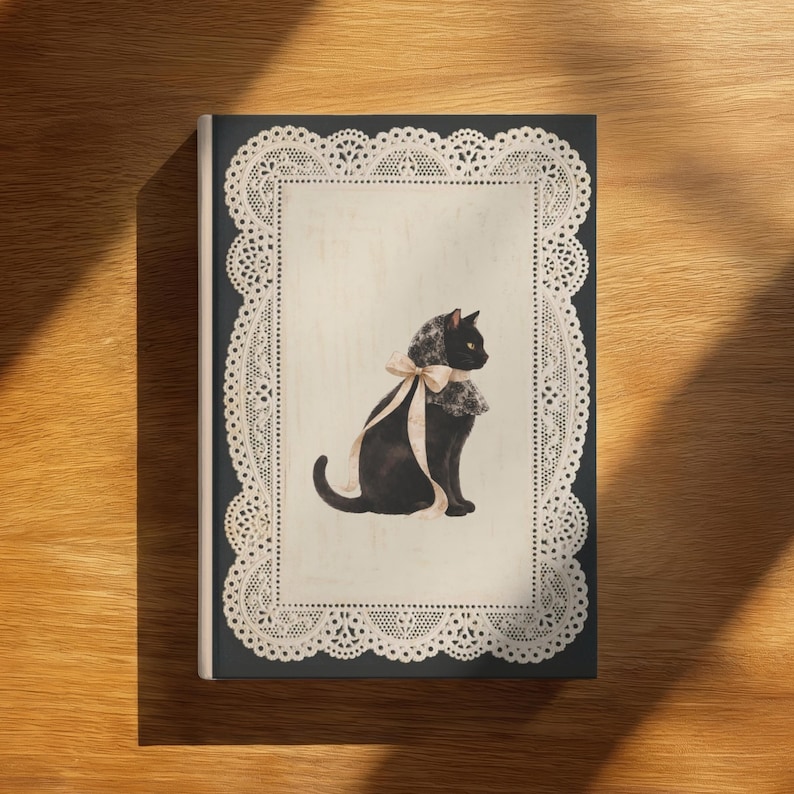 K&ouml;nnte beinhalten: Ein rechteckiges Buch mit dunklem Einband und einem cremefarbenen Mittelfeld, das von einer komplizierten wei&szlig;en Spitzenbord&uuml;re umrahmt wird. In der Mitte ist eine schwarze Katze mit Spitzenhaube und einer hellbeigen Schleife abgebildet.