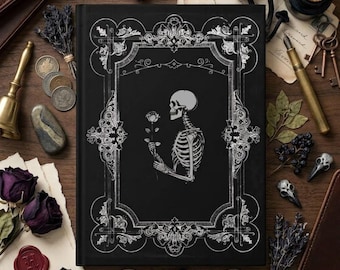 May include: A black hardcover book featuring a white line-art illustration of a skeleton holding a rose, enclosed within an ornate rectangular frame. The cover design includes intricate scrollwork and decorative corner details in white ink.