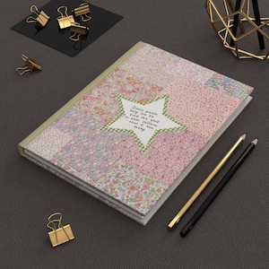 May include: A pink and green floral patterned journal with a star-shaped sticker that says "Jesus please help me to find the good in each instance that I face today".
