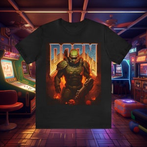 May include: Black t-shirt with a graphic of a green and black Doom Slayer character standing in front of a fiery background with the word "DOOM" in blue and white letters above him.