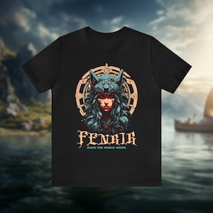以下が含まれることがあります： 狼の耳と円形のデザインを持つ女性のグラフィックがプリントされた黒いTシャツ。グラフィックの下に「Fenrir Make the World Yours」というテキストがプリントされています。