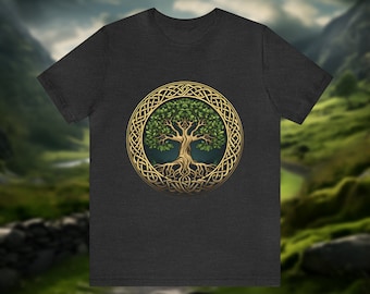 May include: A dark heather grey t-shirt with a Celtic knot design featuring a green tree of life. The tree is surrounded by a gold-colored knot.