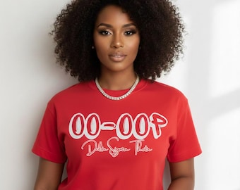 Op de afbeelding: Een rood T-shirt met de tekst "00-00P Delta Sigma Theta" in witte letters. De persoon draagt een diamanten ketting en een gouden horloge. De achtergrond is een effen witte muur.