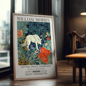 May include: Framed art print featuring a white wolf in a floral landscape with red and yellow flowers. The print is labeled "WILLIAM MORRIS" and advertises a "COTTON PRINTS EXHIBITION" at the Victoria & Albert Museum, South Kensington.