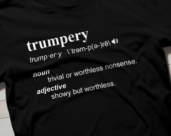 Puede incluir: Camiseta negra con texto blanco que define la palabra "trumpery" como un sustantivo y un adjetivo. La definición dice: "trivial o tontería sin valor." y "ostentoso pero sin valor."