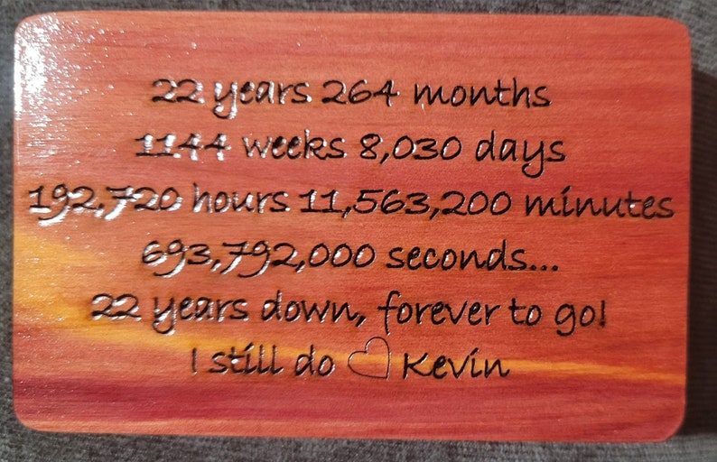 May include: A wooden plaque with a red-brown stain, engraved with the text "22 years 264 months 1144 weeks 8,030 days 192,720 hours 11,563,200 minutes 693,792,000 seconds... 22 years down, forever to go! I still do Kevin".
