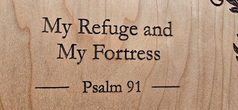 以下が含まれることがあります： 「My Refuge and My Fortress - Psalm 91」というテキストが刻まれた木製の看板です。