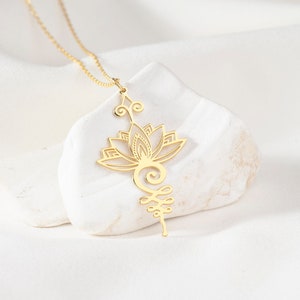 May include: Gold necklace with a lotus flower pendant and a delicate, intricate design. The pendant is suspended from a thin chain.