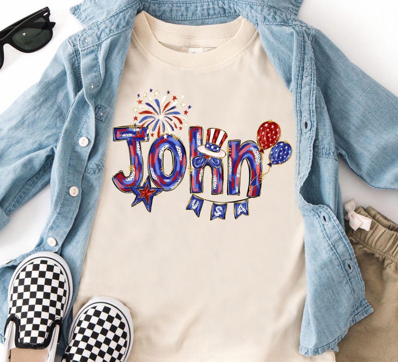 Puede incluir: Una camiseta color crema con el nombre "John" en rojo, blanco y azul, decorada con fuegos artificiales, globos y un sombrero patri&oacute;tico. La palabra "USA" est&aacute; debajo del nombre. La camiseta se combina con una chaqueta vaquera y zapatos a cuadros.
