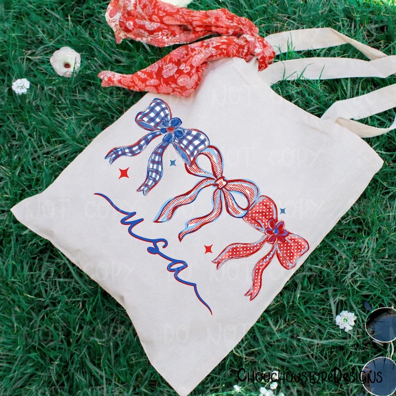 May include: A cream-colored tote bag with three decorative bows in red and blue, with the word "USA" in blue script. The bows have a gingham and polka dot pattern. A red patterned scarf and white straps are also visible.