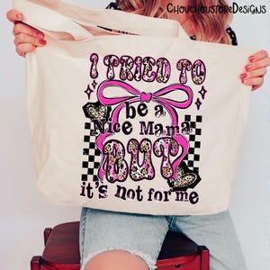 May include: Cream-colored tote bag with a pink and leopard print design. The text on the bag reads "I tried to be a Nice Mama BUT it's not for me." The design includes a pink bow, hearts, and a checkered pattern.