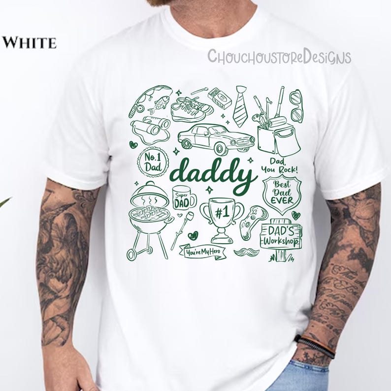 May include: White t-shirt with a green graphic design featuring the word "daddy" and various illustrations like a car, grill, and tools. The shirt also has text that says "Dad You Rock!" and "Best Dad Ever".