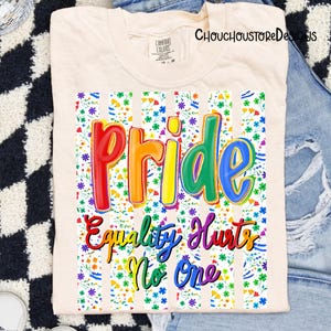 May include: Cream-colored t-shirt with the word "Pride" in rainbow colors, and the phrase "Equality Hurts No One". The design is set against a floral and striped background. The shirt is from the brand "Comfort Colors".