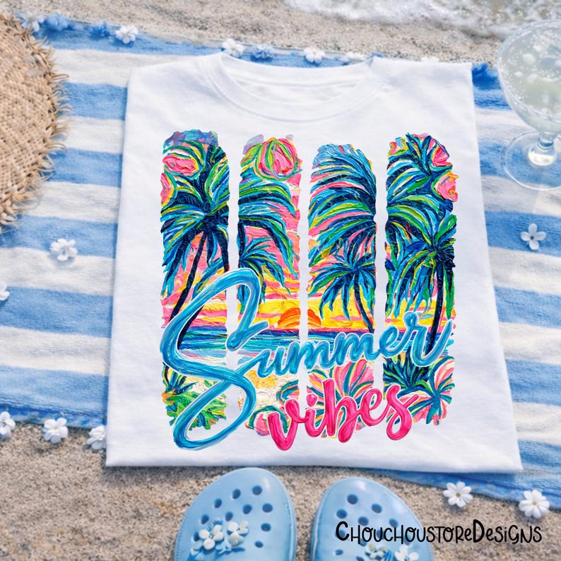 May include: White t-shirt with a colorful "Summer Vibes" design featuring palm trees and a sunset. The text is in blue and pink, evoking a tropical theme. Light blue sandals are at the bottom of the image.