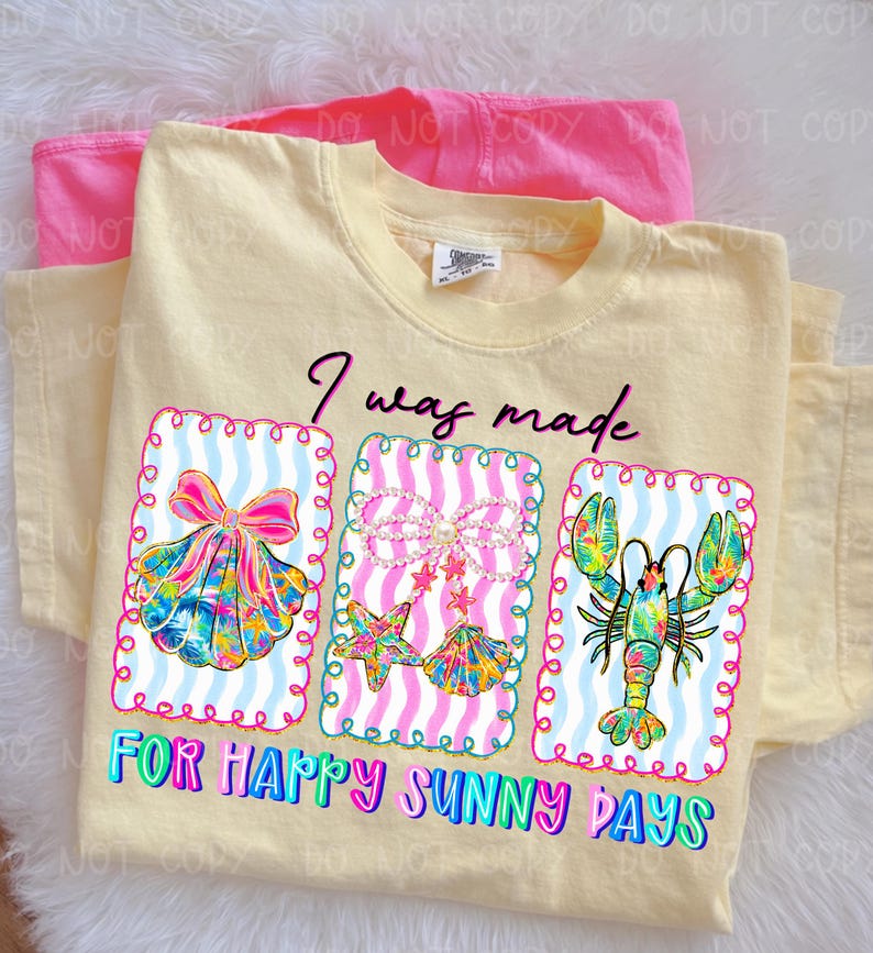 以下が含まれることがあります： 「I was made for happy sunny days」の文字が入った薄い黄色のTシャツ。貝殻、ヒトデと貝殻、ロブスターの3つのフレームグラフィックが特徴です。グラフィックは明るい色です。