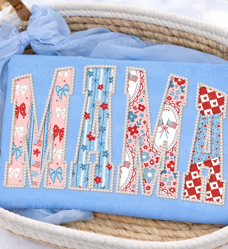 May include: A light blue cushion featuring the word "MAMA" in a patriotic design. Each letter is filled with a different pattern, including bows, flowers, and stars, and is outlined with pearls.