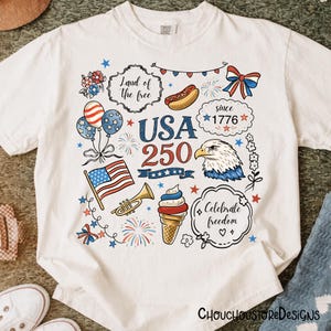 Puede incluir: Camiseta blanca con un dise&ntilde;o patri&oacute;tico que presenta el texto "USA 250" y varias ilustraciones. Incluye una bandera estadounidense, un &aacute;guila, globos, fuegos artificiales y la frase "Land of the free".