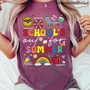 May include: A maroon t-shirt with a colorful graphic that reads "SCHOOL'S out for SUMMER". The design includes a sun, a life preserver, a beach chair, and other summer-themed illustrations. The text "TEACHER OFF DUTY" is also included.