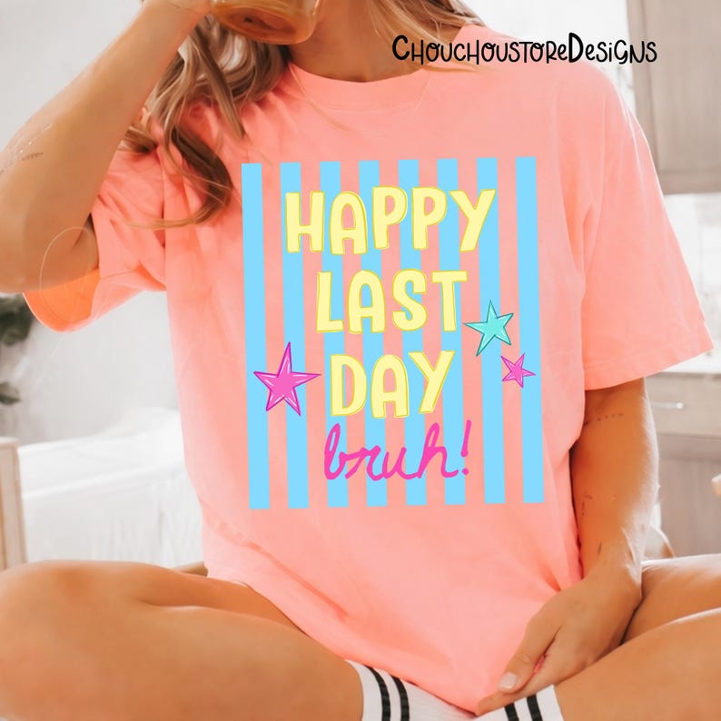 May include: A coral-colored t-shirt with the text "HAPPY LAST DAY bruh!" in yellow and pink, with blue vertical stripes and star accents. The shirt is part of the ChouchoustoreDesigns collection.