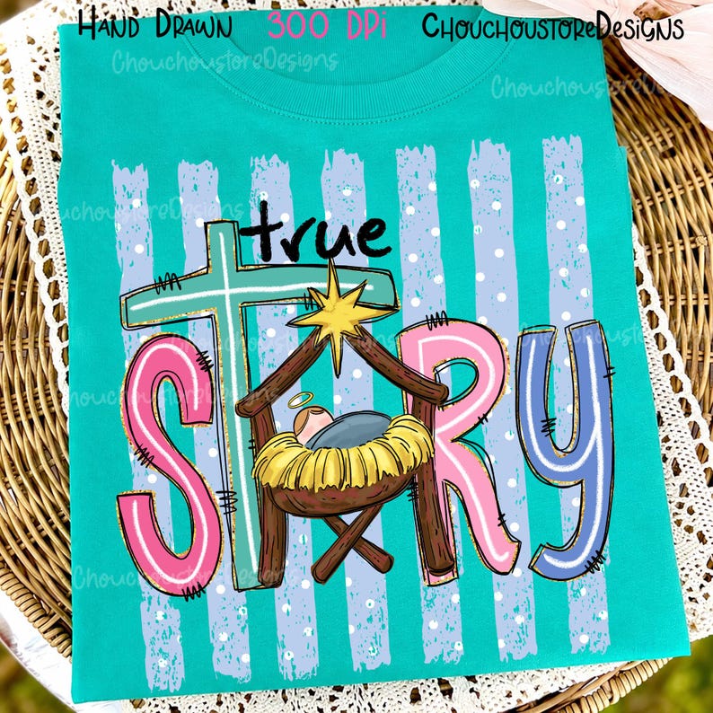 May include: A teal t-shirt featuring a graphic with the text true STORY. The design includes a light blue cross, a yellow star, and a manger scene with a baby in a yellow bed. The background has light blue vertical stripes with white dots.