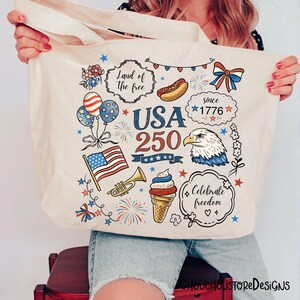 Puede incluir: Bolso tote color crema con ilustraciones patri&oacute;ticas. El dise&ntilde;o incluye una bandera estadounidense ondeando, globos, fuegos artificiales, un perrito caliente y un helado. El texto incluye "USA 250" y "Celebra la libertad."