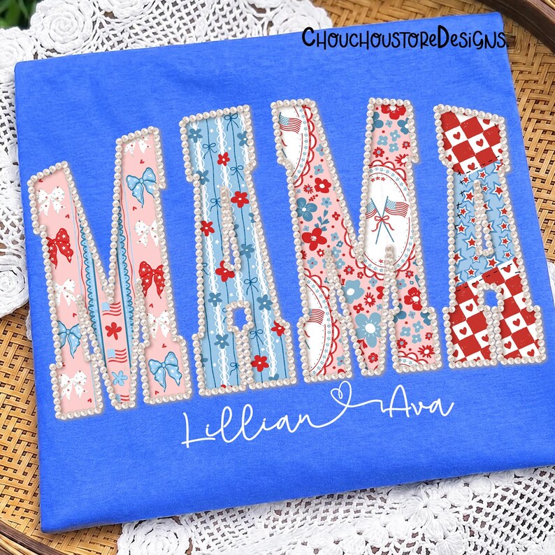 May include: A blue t-shirt featuring the word "NANA" in a decorative font. The letters are adorned with bows, floral patterns, and patriotic motifs. The names "Lillian & Ava" are written below the word "NANA".