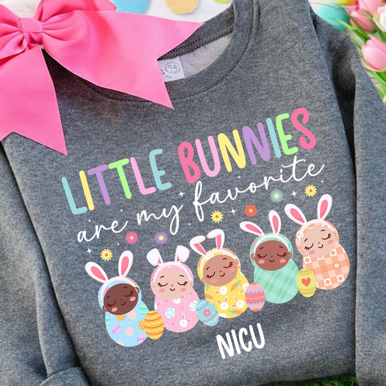 May include: A gray sweatshirt with the text "LITTLE BUNNIES are my favorite" in colorful letters. Below are five cartoon bunnies in different colored outfits, each holding an Easter egg. The word "NICU" is printed at the bottom.