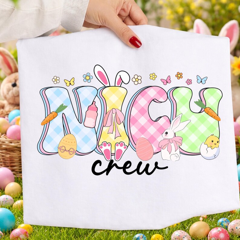 May include: White Easter-themed towel with the words "NICH CREW" in colorful, checkered letters. The design includes Easter eggs, bunnies, carrots, and flowers. The towel is held up by a person with red nail polish.
