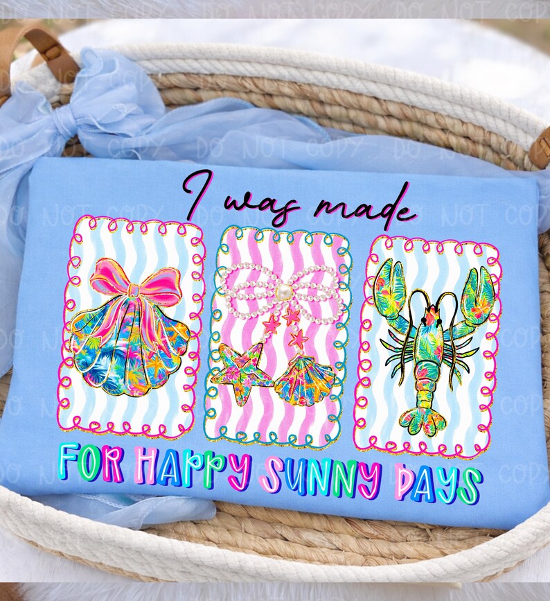 以下が含まれることがあります： 「I was made for happy sunny days」の文字が入った水色のTシャツ。 3つのフレームデザインがあり、リボン付きの貝殻、真珠付きのヒトデと貝殻、ロブスターが描かれています。 デザインは明るい色です。