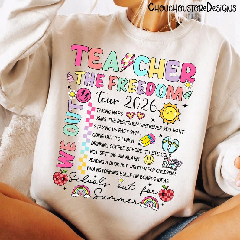 May include: A white sweatshirt with the text "TEACHER THE FREEDOM Tour 2026" in colorful bubble letters. The design includes a list of fun activities and the phrase "School's out for Summer".