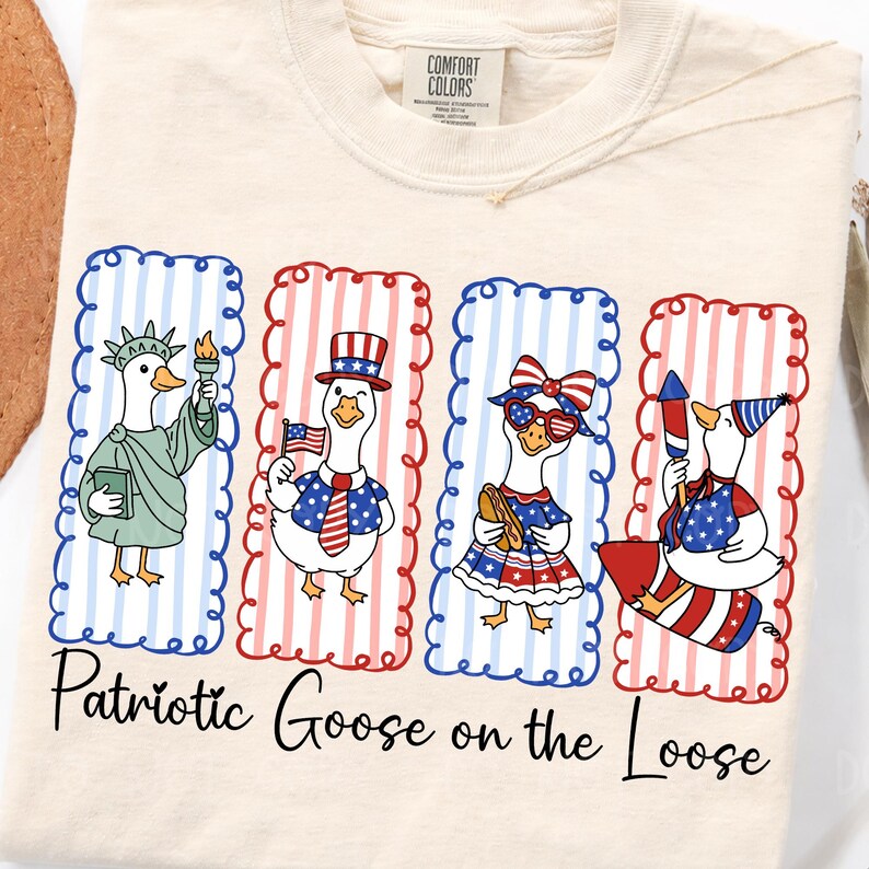 May include: Cream-colored t-shirt featuring four cartoon geese in patriotic attire. Each goose is in a rectangular frame with red and blue accents. The text "Patriotic Goose on the Loose" is printed below the geese.