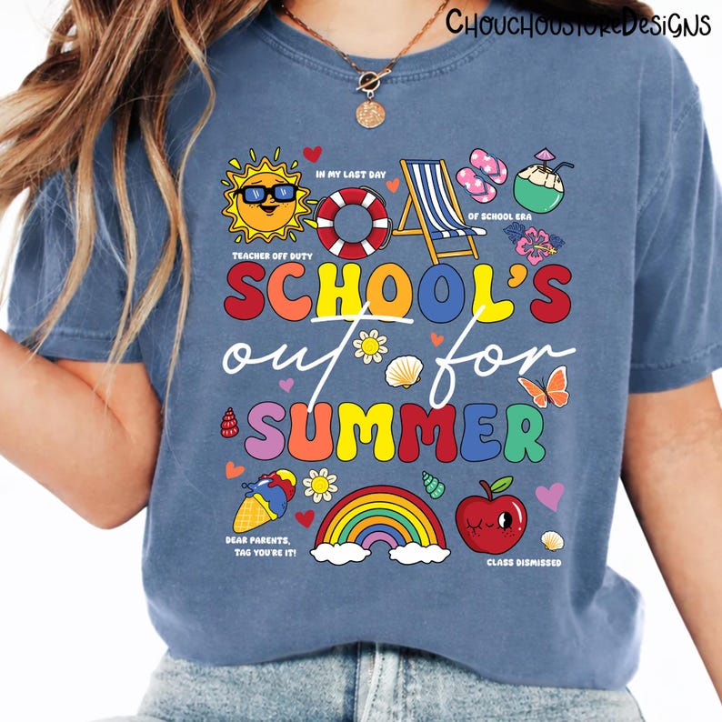 May include: Blue t-shirt with a colorful graphic design. The design includes the text "SCHOOL'S out for SUMMER" with various summer-themed illustrations such as a sun, rainbow, and apple. The shirt also has additional text.