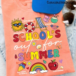 May include: Peach-colored t-shirt with a colorful graphic that reads "School's Out for Summer." The design includes a sun wearing sunglasses, a rainbow, and other summer-themed illustrations. A blue cap and sunglasses are also visible.